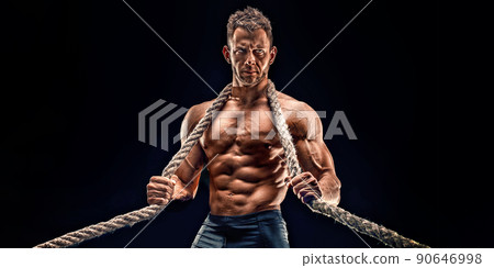 portrait of strong Athletic Fitness man showing big muscles over black background 90646998