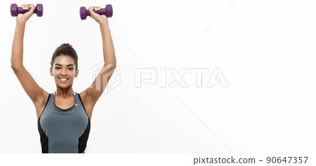 Healthy and Fitness concept - Beautiful American African lady in fitness clothes workout with dumbbell. Isolated on white background. 90647357