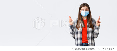 Coronavirus outbreak, leisure on quarantine, social distancing and emotions concept. Hopeful optimistic cute girl in medical mask have faith, cross fingers good luck, making wish or praying Coronavirus outbreak, leisure on quarantine, social distancing and emotions concept. Hopeful optimistic cute girl in medical mask have faith, cross fingers good luck, making wish or praying 90647457