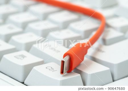 The orange cable with the type-c connector is on the white keyboard 90647680