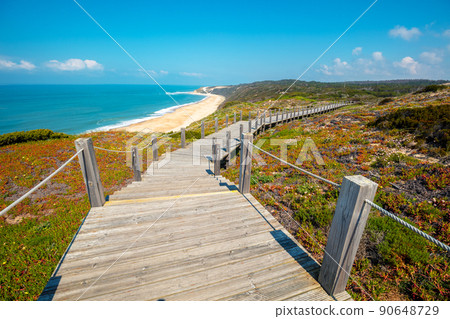 The wooden stairway at the rocky seashore on a sunny day. Polvoeira the beach. Pataias, Portugal, Europe The wooden stairway at the rocky seashore on a sunny day. Polvoeira the beach. Pataias, Portugal, Europe 90648729