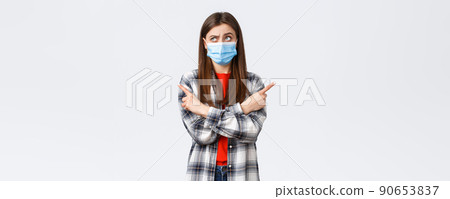 Coronavirus outbreak, leisure on quarantine, social distancing and emotions concept. Indecisive young woman making choice. Girl in medical mask puzzled facing decision, point sideways, think Coronavirus outbreak, leisure on quarantine, social distancing and emotions concept. Indecisive young woman making choice. Girl in medical mask puzzled facing decision, point sideways, think 90653837