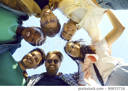 Group of happy cheerful young multiracial friends hugging, looking down and smiling 90655716