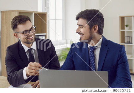 Happy smiling insurance agent or loan advisor meeting with a client in his office Happy smiling insurance agent or loan advisor meeting with a client in his office 90655731