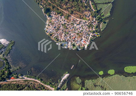 Small island with village, townhomes, forest, boats and yachts in the middle of lake. Drone view, aerial view, top view 90656746