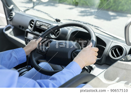 The hand of a man holding the handle of a truck 90657510