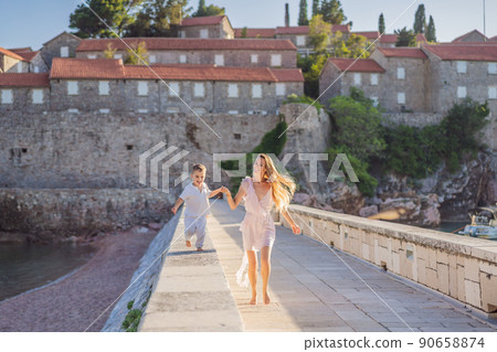 Mother and son tourists on background of beautiful view St. Stephen island, Sveti Stefan on the Budva Riviera, Budva, Montenegro. Travel to Montenegro concept 90658874