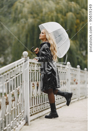 Girl walks. Woman in a black coat. Blonde with a umbrella. Girl walks. Woman in a black coat. Blonde with a umbrella. 90659149
