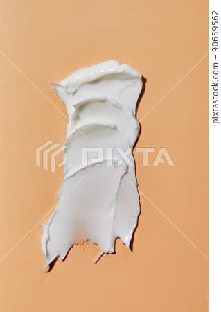 Smear of white cream in peach background. Beauty creme smear swatch. Cream, Lotion for face or body. 90659562