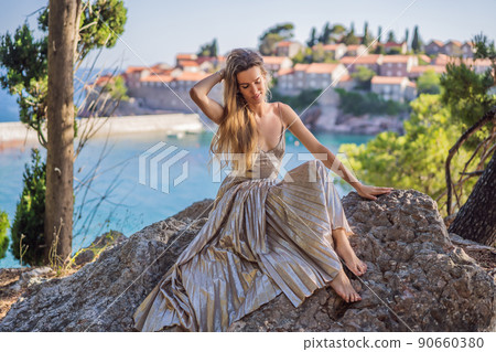 Woman tourist on background of beautiful view of the island of St. Stephen, Sveti Stefan on the Budva Riviera, Budva, Montenegro. Travel to Montenegro concept 90660380