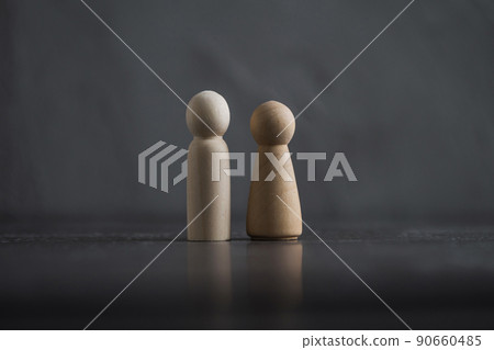 Wooden people man and woman against the background of a dark gray concrete wall. The concept of family, friendship, relationships. Wooden people man and woman against the background of a dark gray concrete wall. The concept of family, friendship, relationships. 90660485