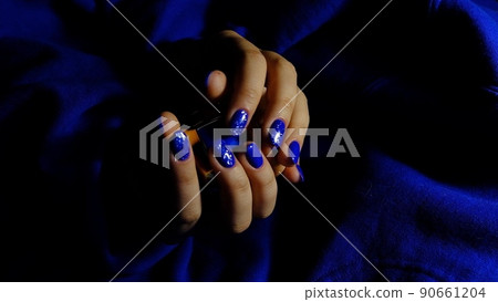 womans hands with blue manicure on blue textured background womans hands with blue manicure on blue textured background 90661204