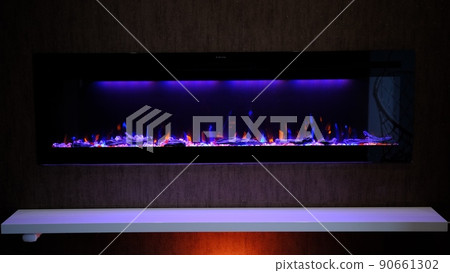 view on electric fireplace with artificial sparkling flame, decor for the interior, orange and blue flame view on electric fireplace with artificial sparkling flame, decor for the interior, orange and blue flame 90661302