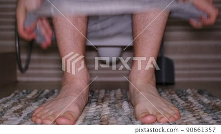 Man sitting in toilet. Diarrhea concept. Hairy legs of a man with grey underwear pantys moving feet 90661357