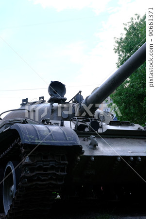 view of the front part of the green caterpillar of the tank standing on the ground with the wheels close-up 90661371