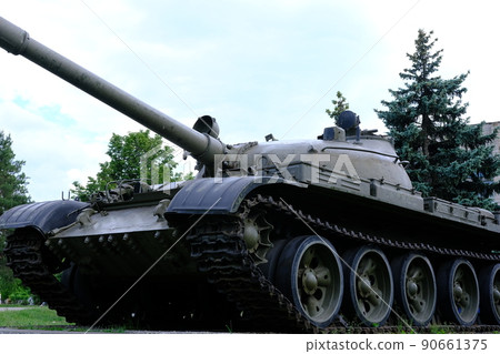 view of the front part of the green caterpillar of the tank standing on the ground with the wheels close-up 90661375