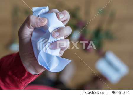 hand of woman with crumpled paper of letter among scattered flowers. Broken relationships in bad Valentine's day. concept. hand of woman with crumpled paper of letter among scattered flowers. Broken relationships in bad Valentine's day. concept. 90661865