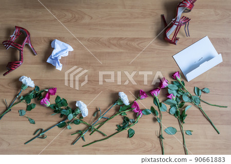 crumpled paper of letter and scattered flowerson the floor. Broken relationships in bad Valentine's day. concept. crumpled paper of letter and scattered flowerson the floor. Broken relationships in bad Valentine's day. concept. 90661883
