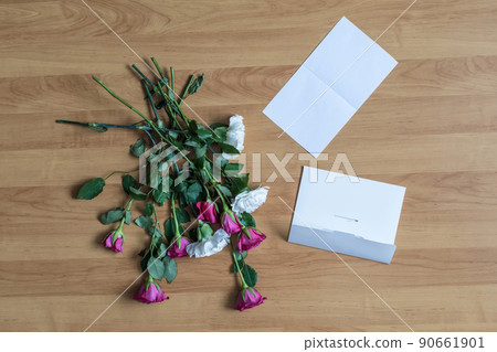 paper of letter and scattered flowers on the floor. Broken relationships in bad Valentine's day. concept. paper of letter and scattered flowers on the floor. Broken relationships in bad Valentine's day. concept. 90661901