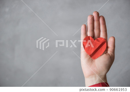 woman hand with crumpled paper red heart against the concrete floor.  Broken relationships in bad Valentine's day. concept. 90661953