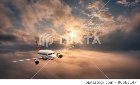 Airplane is flying above the clouds at sunset in summer Airplane is flying above the clouds at sunset in summer 90663147