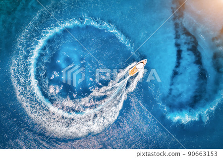 Aerial view of the speed boat in clear blue water at sunset 90663153