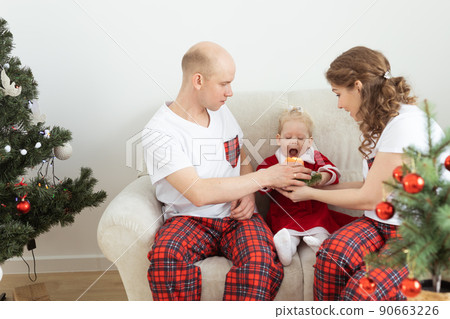 Baby child with hearing aid and cochlear implant having fun with parents in christmas room. Deaf , diversity and health concept 90663226