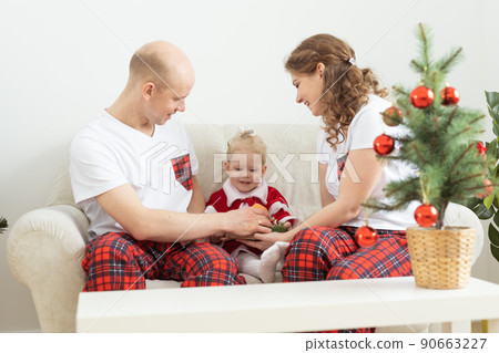 Baby child with hearing aid and cochlear implant having fun with parents in christmas room. Deaf , diversity and health concept 90663227