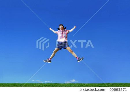 One young girl who spreads her limbs and jumps against the background of the blue sky 90663271