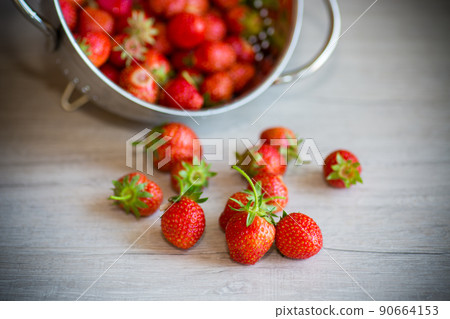 red ripe natural strawberries on a wooden table 90664153