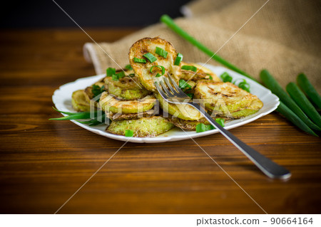 fried zucchini in circles with fresh herbs in a plate fried zucchini in circles with fresh herbs in a plate 90664164