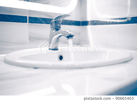 tap faucet with flowing water, blue tone 90665403