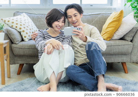 一對夫婦在客廳看智能手機時放鬆 90666036