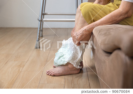Urinary Incontinence in elderly and changing diaper. 90670084