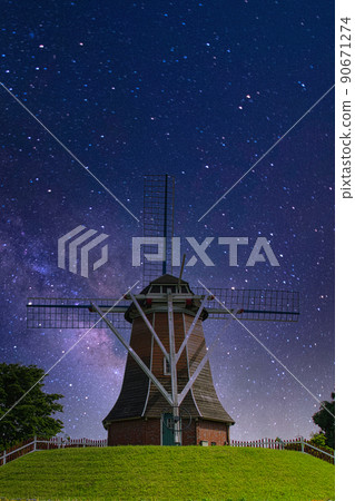 A night view of a quaint windmill towering on a hill, which is rare in Japan 90671274