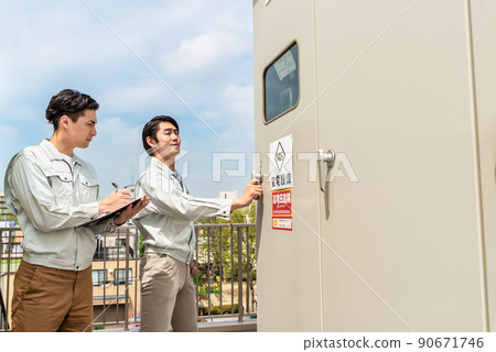 Technician checking the electrical equipment installed on the roof 90671746