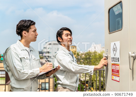 Technician checking the electrical equipment installed on the roof 90671749