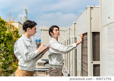 檢查安裝在屋頂的空調設備的技術員 90671750