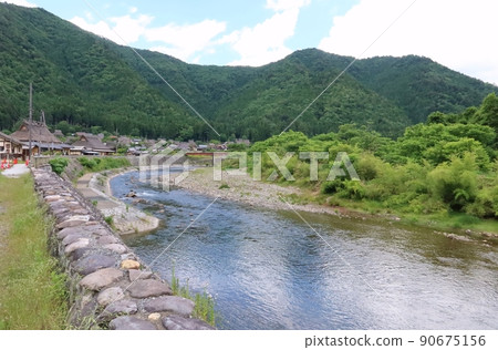 A landscape of the Yura River and the preservation area of a traditional Japanese house in Miyama-cho, Nantan City, Kyoto Prefecture. 90675156