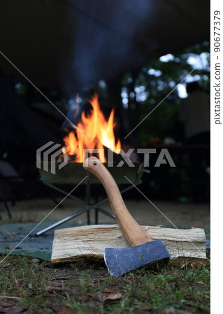Bonfire and ax using a bonfire at a spring campsite 90677379