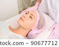 Image of a young beautiful woman dressed as a patient, lying on a couch in a cosmetology clinic. 90677712