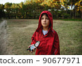 A boy in a red windbreaker against the backdrop of a forest with a compass in his hand. 90677971