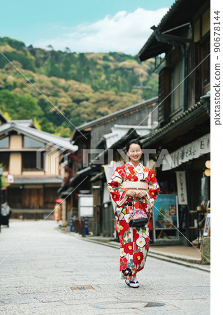 A young woman walking around Kyoto in a kimono 90678144