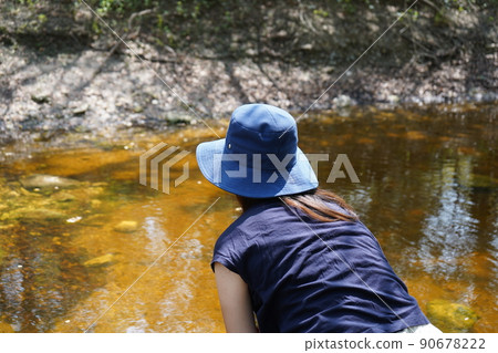 A woman looking into a river in San Antonio Park, Texas A woman looking into a river in San Antonio Park, Texas 90678222