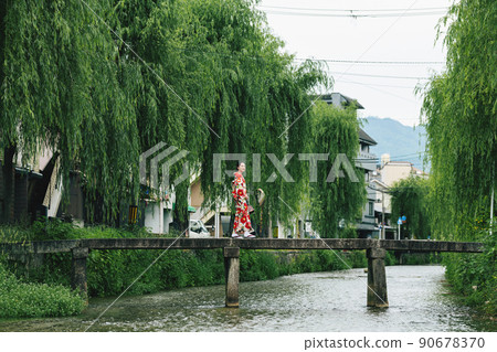 一個穿著和服的女人沿著古河町橋走 90678370