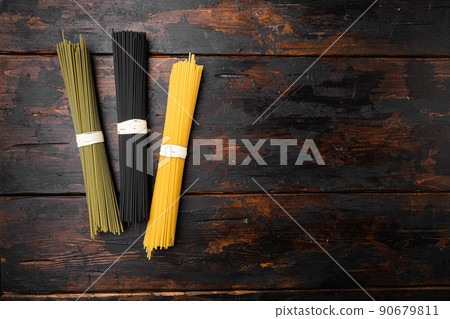 Multi colored spaghetti with ingredients, on old dark wooden table background, top view flat lay, with copy space for text Multi colored spaghetti with ingredients, on old dark wooden table background, top view flat lay, with copy space for text 90679811