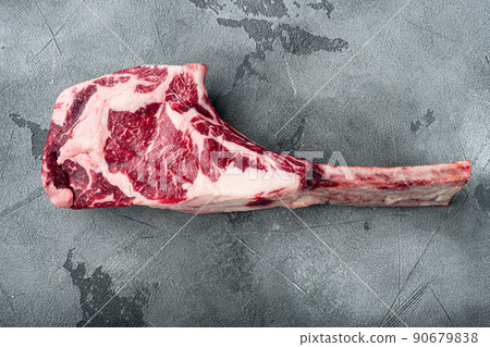 Raw fresh tomahawk black angus prime beef chop steak, on gray stone background, top view flat lay, with copy space for text 90679838