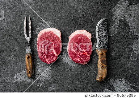 Fresh beef steak sliced, on black dark stone table background, top view flat lay Fresh beef steak sliced, on black dark stone table background, top view flat lay 90679899