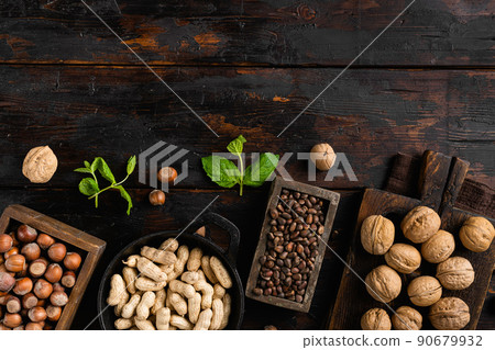 Assortment of nuts in shells, peanut, walnut, pine nuts and hazelnut, on old dark  wooden table background, top view flat lay, with copy space for text 90679932