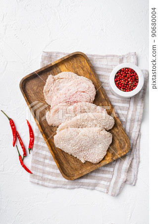 Raw schnitzel chicken meat set, on white stone table background, top view flat lay Raw schnitzel chicken meat set, on white stone table background, top view flat lay 90680004